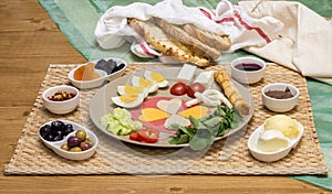 Close up of traditional Turkish breakfast served with cheese, salami, boiled egg, tomato, cucumber and toasted bread