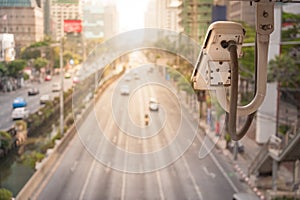 Close-up of traffic camera observes vehicular traffic on a road