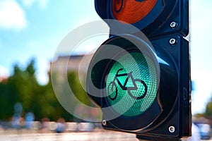 Close-up of a traffic light for cyclists, which is glowing green. A bicycle is shown on the traffic light