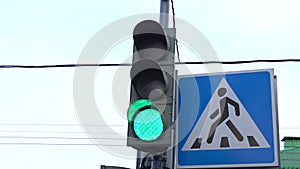 Close-up of a traffic light pedestrian crossing, the traffic light switches from green to red. City street at daytime.