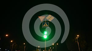 Close-up of traffic lights at night. Traffic signal light changes from red to green at night.