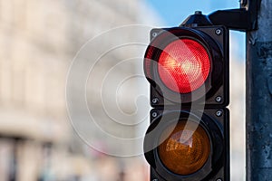 Close-up of traffic semaphore with red light on defocused city street background with copy space