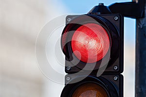 Close-up of traffic semaphore with red light on defocused city street background with copy space