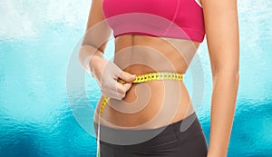 Close up trained belly with measuring tape