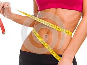 Close up of trained belly with measuring tape