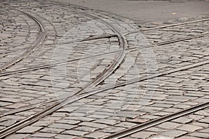 Close up on a tramway rail switch on a cobblestone pavement on an old and obsolete street