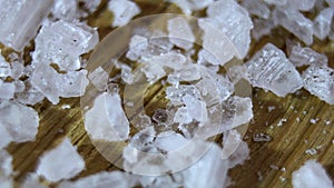 Close-up. Translucent cube-shaped salt crystals rotated on the floor. Natural sea salt.