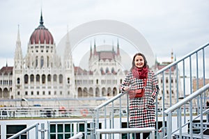 Close-up turist girl stands on steps against Hungarian Parliament, Budapest