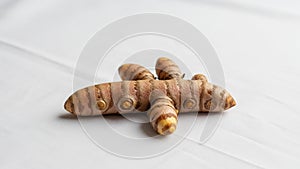 A close up of a turmeric root Curcuma longa on a white surface
