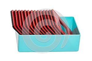 Close-up of a turquoise plastic box with red and black framed film slides isolated on a white background. Entertainment last