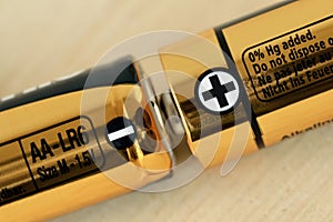 Close-up of two AA size batteries with plus and minus signs - Concept of energy and positive and negative poles