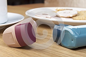 Close up of two asthma inhalers on a breakfast table