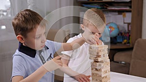 Close-up of two boys playing an exciting board game with wooden cubes.