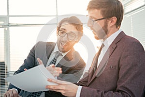 Two business men discussing a business document.