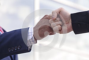 Close-up of two businessmen giving fist bump