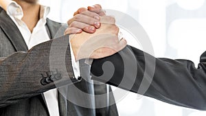 Close up of two businessmen in gray business suit gripping their