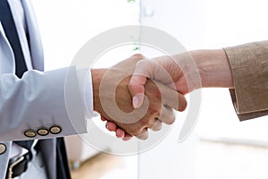 Two bussines partners shaking their hands in the office. photo