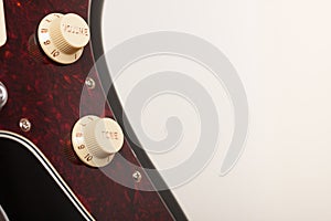 Close up of two conectors on  black electric guitar, studio shoot. Red tortoise shell pickguard