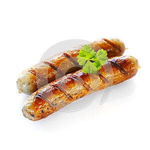 Close up of two cooked sausages against white