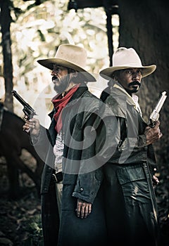 Close up Two cowboys standing and holding short gun