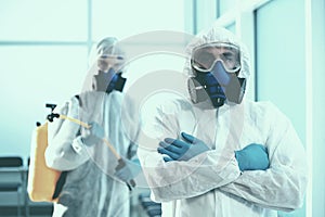 close-up. two disinfectors exit the decontaminated room .