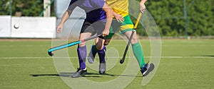 Close up of two field hockey players, challenging eachother for the control and posession of the ball during an intense, competiti