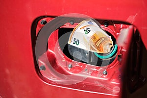 Close up of two fifty euro banknotes in an open tank of a red car