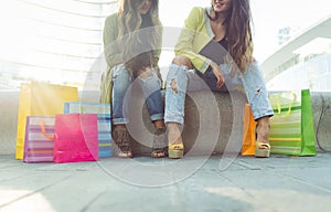 Close up on two girls with shopping bags