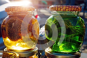 Close-up of two glass jars honey with green leaves and nuts in market