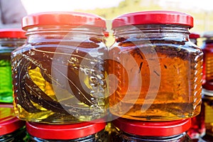 Close-up of two glass jars honey with leaves in market