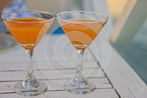 Close-up of two glasses of alcoholic drink in restaurant on white table.