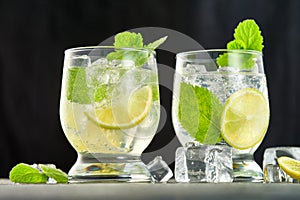 Close-up of two glasses of mojito cocktail with ice cubes on a dark background. Low angle view. Studio shot