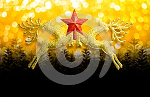 Two golden reindeer with red star on circular bokeh yellow gold background and copy space, concept christmas day.
