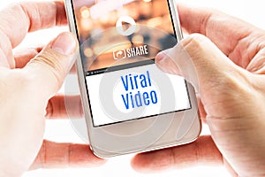 Close up Two hand holding smart phone with Viral Video word and