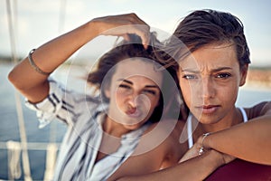 Close-up of two handsome female models who is posing for a photo on a yacht. Summer, sea, vacation, friendship