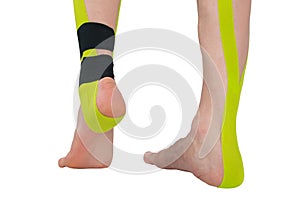 Close-up of two legs, with medical tapes pasted on to support and relax the muscles when doing sports