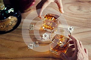 Close-up of two men clinking glasses of whiskey drink alcohol