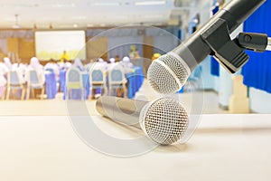 Close up two microphone wireless Stand on white table in business conference interior seminar meeting room