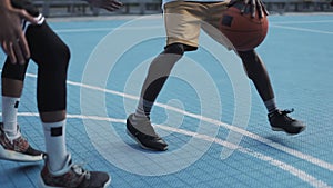 Close up of two mixed race mens legs playing basketball, Afro American dribbling and throwing ball, one on one at the