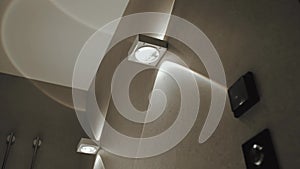 Close-up of two modern square lamps on the wall in a bathroom light turned on. Bathroom sconce. Close-up of an