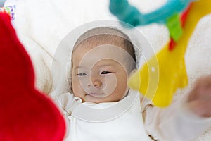 Close - Up Two month old new born asian cute baby playing on play gym toy