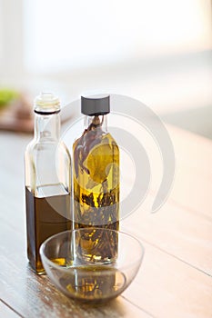 Close up of two olive oil bottles and bowl of oil