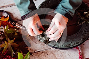 a close up of two people& x27;s hands making a wreath