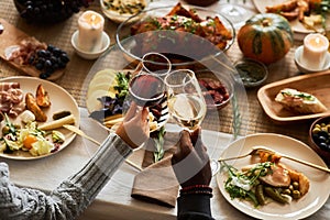 Close up of two people toasting celebrating Thanksgiving with friends and family
