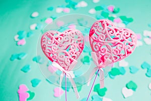 Close-up of two pink hearts with patterns on a festive bright green background