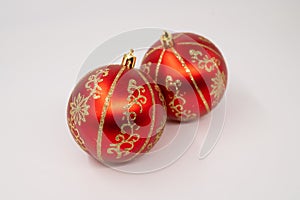 Close-up of a two red Christmas bulb with golden stripes on it on an isolated white background