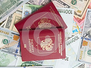 Close-up of two Russian passports lying on banknotes dollars and euros The concept of traveling around the world. Top view, flat