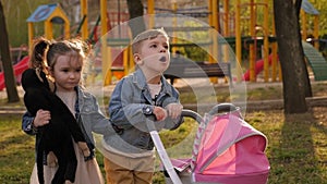 Close-up of two small children playing in the Park with toys and a pram.