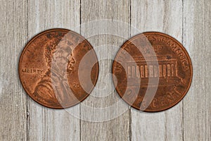 Close-up of two USA pennies on weathered wood