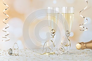 Close up of two wine flutes filled with champagne and wedding rings inside. Engagement or Wedding Anniversary concept.